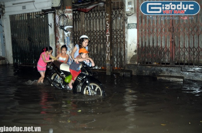 Trẻ em cũng được huy động để đẩy xe vượt qua đoạn đường ngập nước
